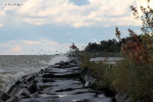 Waves crash against the breakwall.