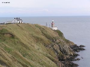 The lighthouse sitting on the cliff.