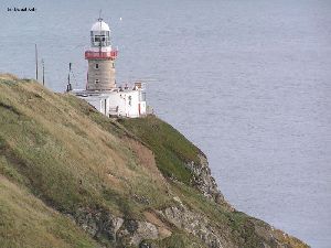 The lighthouse sitting high above the water.