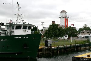 A ship docked by the lighthouse.