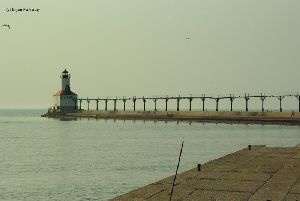 Birds soar near the lighthouse.